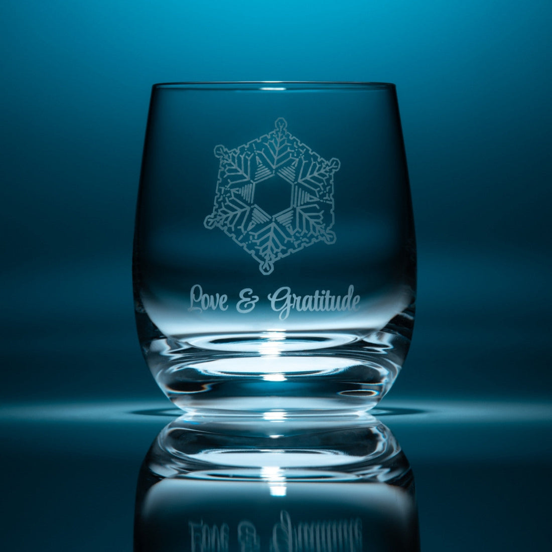 vaso de agua de cristal flaska emoto amor y gratitud delante de su caja