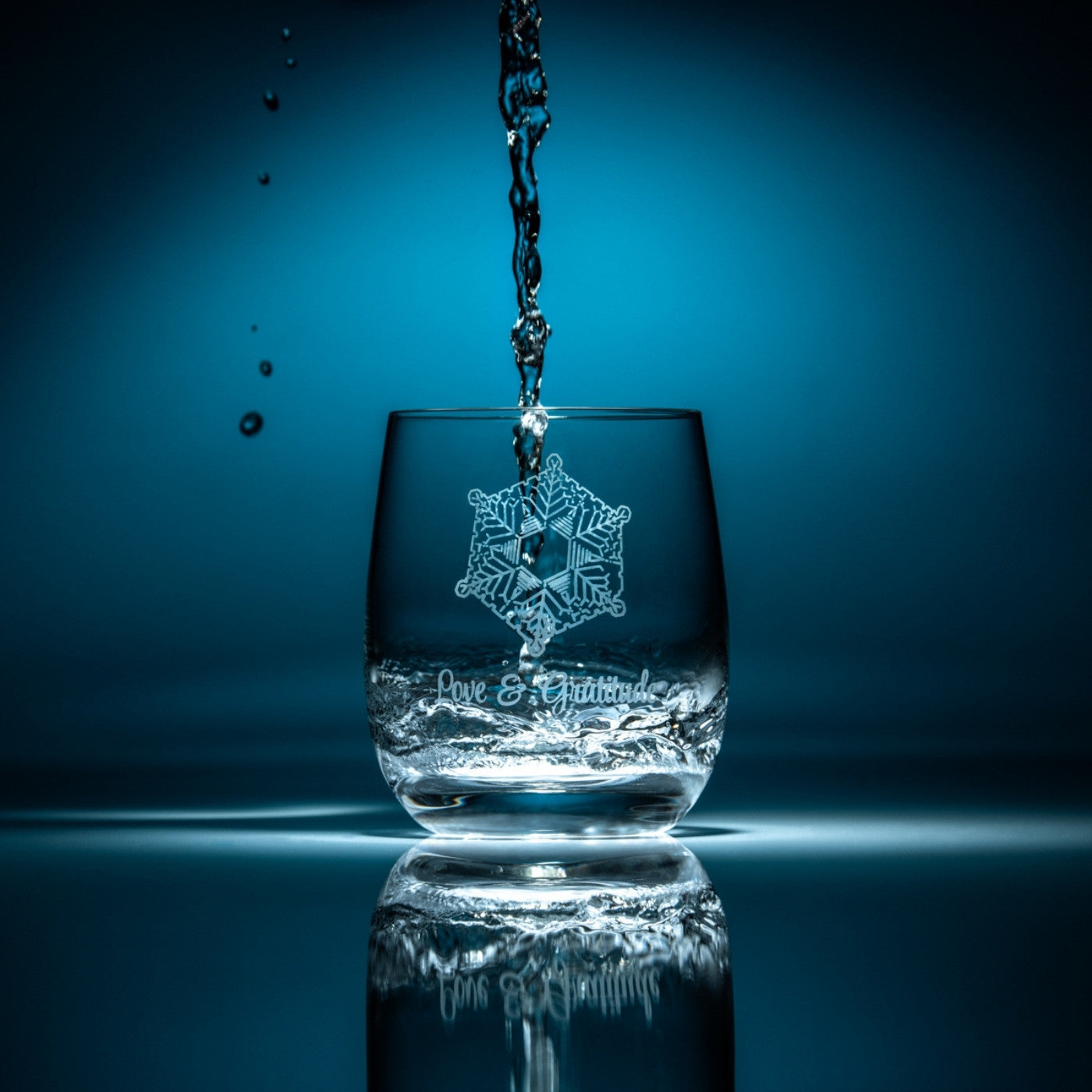 agua cayendo en vaso de agua de cristla flaska masaru emoto amor y gratitud
