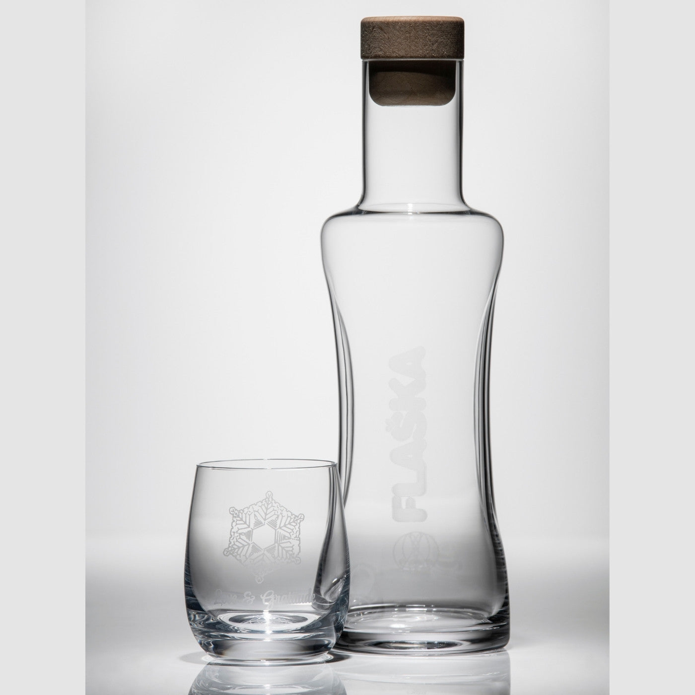 vaso de agua de cristal emoto junto a jarra de cristal de agua Flaska fondo sombras
